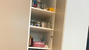 A pantry with shelves containing jars, containers, and kitchen items. - Central, family-friendly apartment with terrace and underground garage in Essen (Essen)