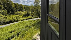 Une vue depuis une fenêtre d’un immeuble, avec une rivière et de la verdure en arrière-plan.