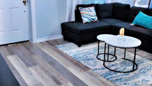 A modern living room with a dark sofa, a round coffee table, and a white door. - Cozy 3 BR Family Home Near OU Hospital (Oklahoma City)