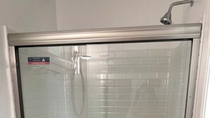 A glass-enclosed shower stall with a showerhead, a toilet, and a control panel. - Micro Studio With Outdoor Space Near Nike & Intel (Beaverton)