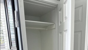 A white closet with two shelves and a door with a black handle. - Micro Studio With Outdoor Space Near Nike & Intel (Beaverton)