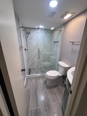 Een douche, handdoeken, zeep, toiletpapier