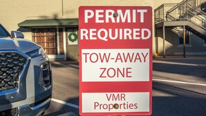 Een bord waarop staat dat er een vergunning nodig is in een zone waar auto's afgesleept kunnen worden op VMR-terrein.