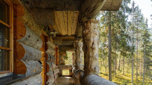 A log cabin interior with a wooden staircase leading to a window overlooking a forest. - Comfy Cabin Retreat Close To The Rukatunturi Ski Slopes (Ruka)