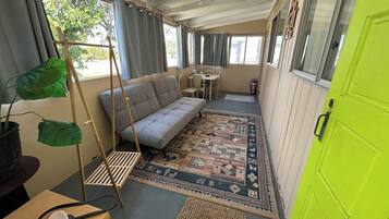 A compact room with a sofa, a small table, and a chair.