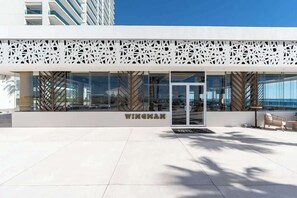 A modern building with a glass facade, a white decorative facade, and the name 'WINGHAM' on the ground floor.