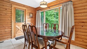 A wooden interior with a round glass table and chairs, large windows with curtains, and a ceiling light fixture. - Pet Friendly, Views, Lake Lure Access, Wi Fi - My Mountain Paradise (Lake Lure)