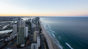 Une vue aérienne d’une ville côtière avec de hauts immeubles, une plage et une rivière.