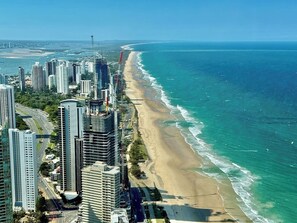 Eine Küstenstadt mit Hochhäusern, einem Strand und blauem Himmel.