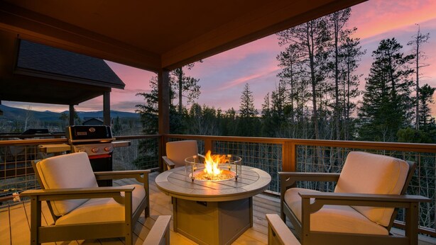 Una terraza con una mesa redonda y sillas, una parrilla y una chimenea.