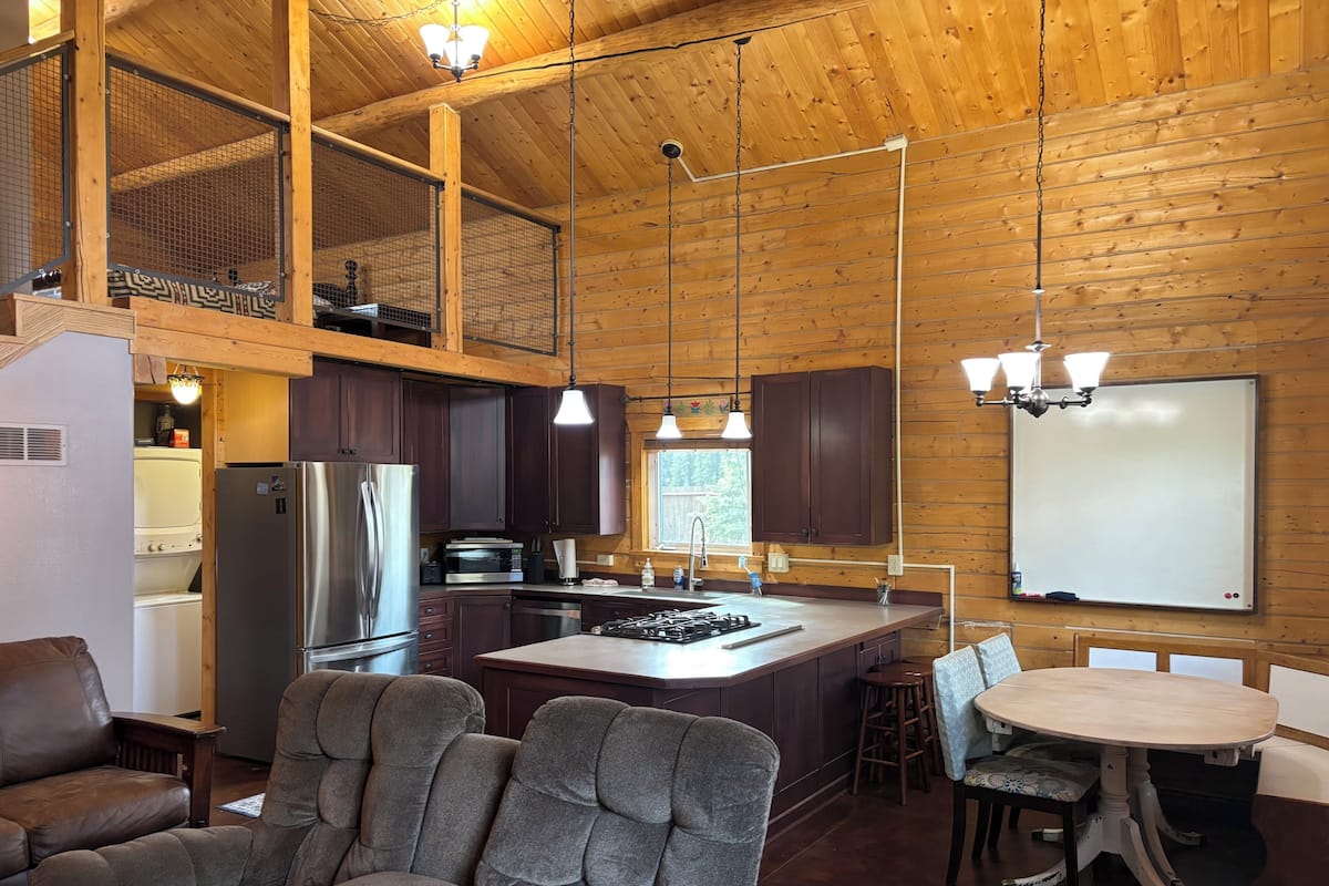 A spacious kitchen with wooden walls, a large island, and modern appliances.