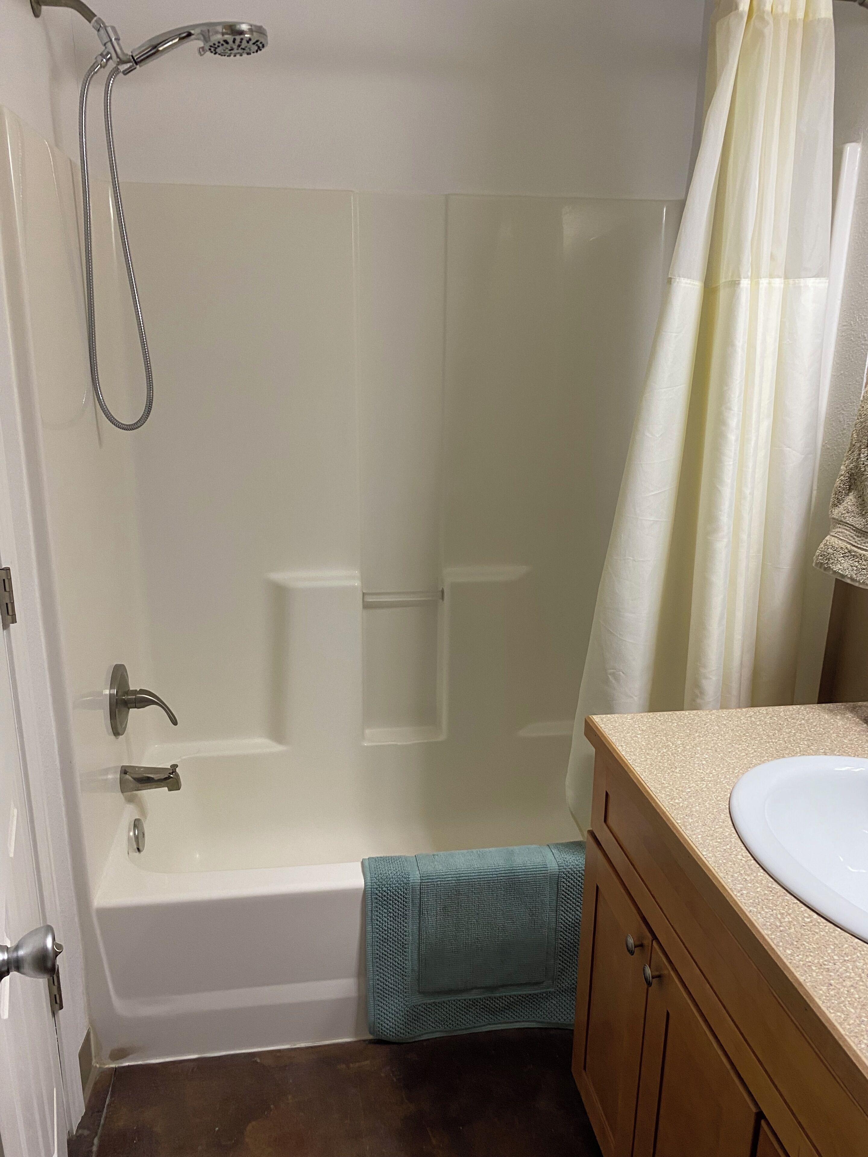 A bathroom with a bathtub, a shower, a sink, and a towel rack.