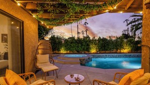 A poolside area with wicker chairs, a small table, and a hot tub. - Azure Oasis - Saltwater Pool/Spa with putting green! (Palm Desert)