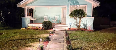 A single-story house with a front porch, a small front yard, and a pathway leading to the entrance.