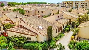 A residential area with terracotta-tiled roofs, small gardens, and a mix of single and multi-story buildings. - Les Maisons de la Plage by Interhome (Le Grau du Roi)