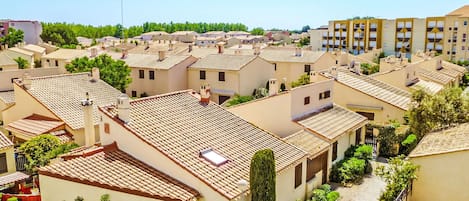 A residential area with terracotta-tiled roofs, small gardens, and a mix of single and multi-story buildings.