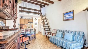 A cozy living room with a wooden staircase, a dining area, and a kitchen. - Les Maisons de la Plage by Interhome (Le Grau du Roi)