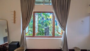 A room with a window, curtains, a sofa, a chair, and a small table. - Nomads Hideaway Near Matara Railway Station (Matara)