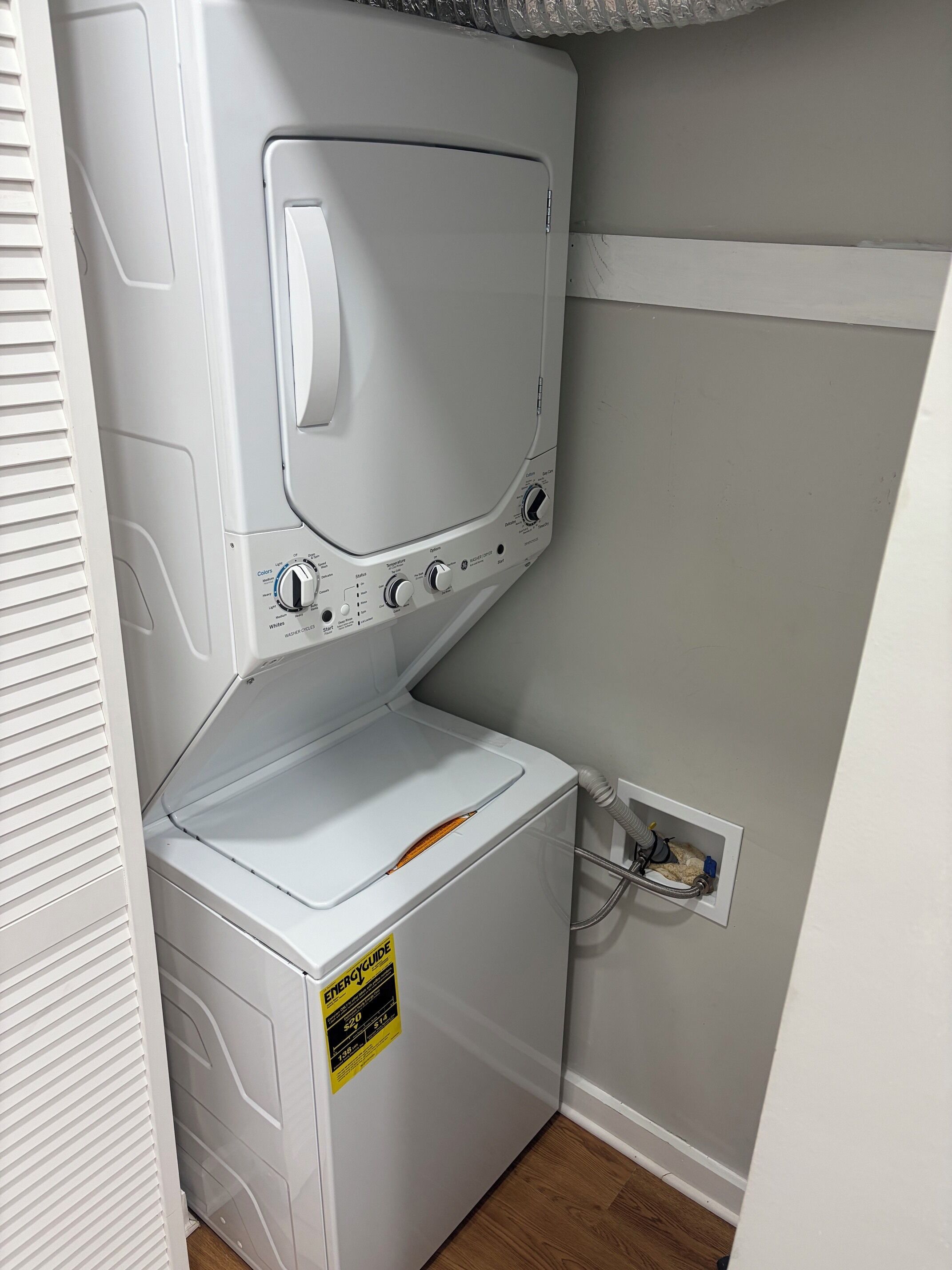A compact washer and dryer unit with a control panel, a power cord, and an ENERGYGUIDE sticker.