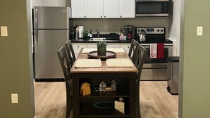 A compact kitchen with white cabinets, a microwave, and a stove.