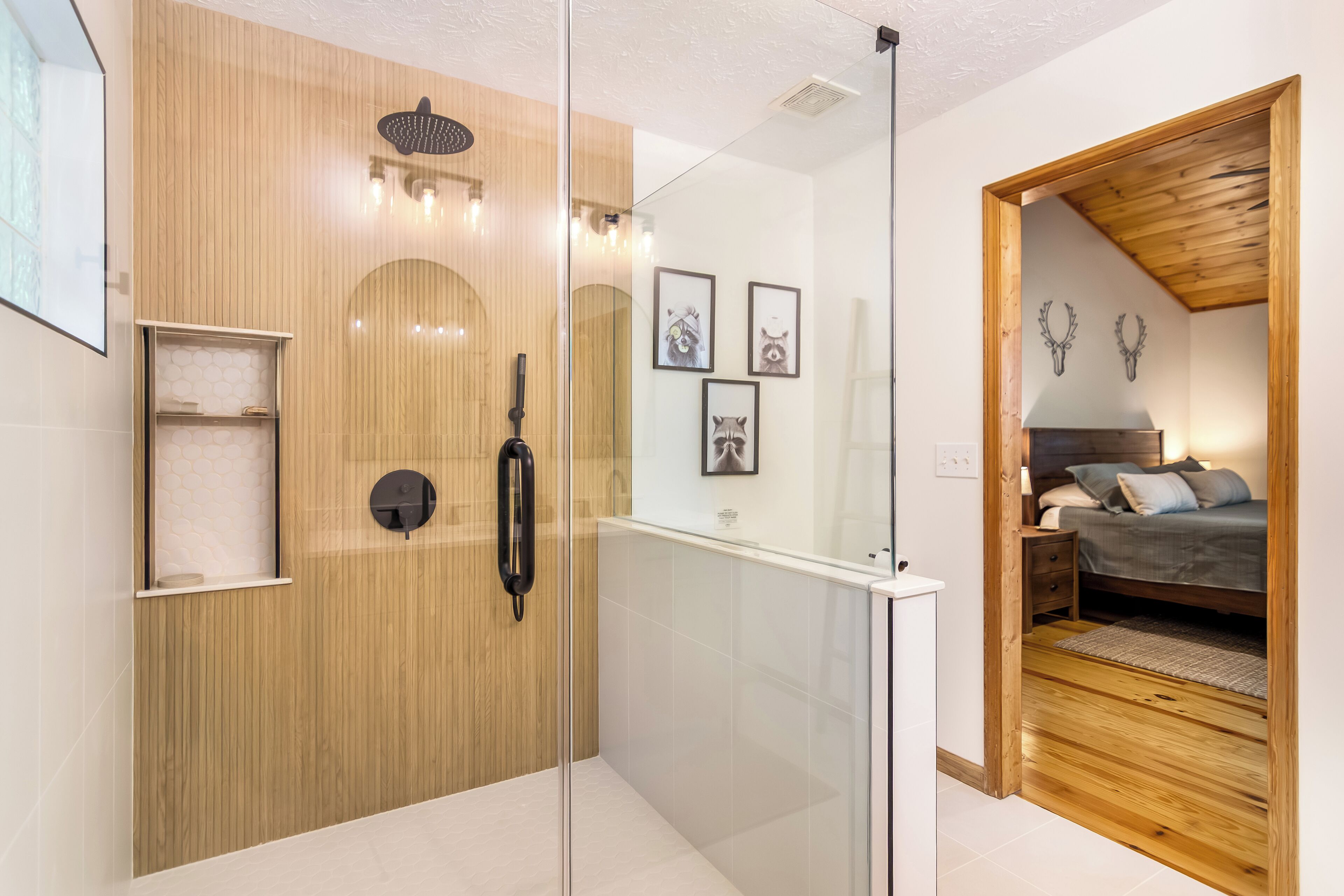 Un baño moderno con cabina de ducha de vidrio, paneles de madera y un estante pequeño con artículos de aseo.
