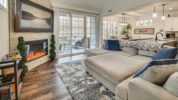 A spacious living room with a fireplace, a large sofa, and a dining area with a view.