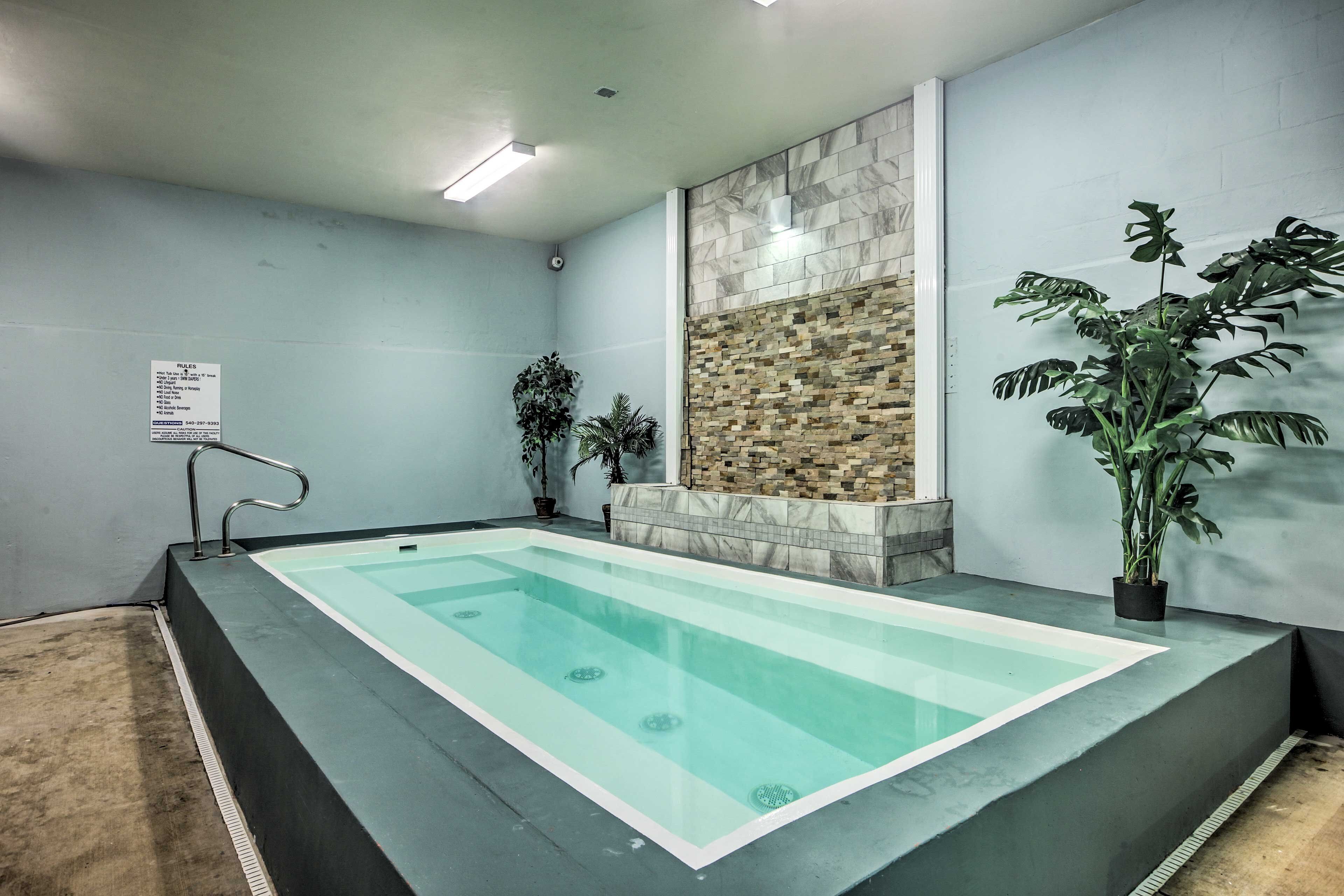 Une piscine intérieure rectangulaire à eau claire, entourée d’une plateforme basse.