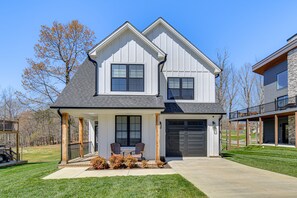 A two-story house with a garage, a covered porch, and a landscaped front yard. - Mariners Cottage - Stunning SML Getaway with Resort Perks at Mariners Landing! (Huddleston)