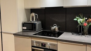 A modern kitchen with stainless steel appliances, a microwave, a stove, and a built-in oven. - Double room in Luxury new flat. 1min to bus stop & grocery store! (Brentford)