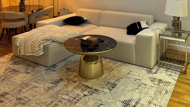 A modern living room with a white sofa, a glass coffee table, a chandelier, and a floor lamp. - Double room in Luxury new flat. 1min to bus stop & grocery store! (Brentford)