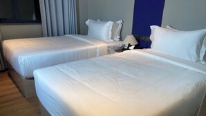 A hotel room with two single beds, a nightstand with a lamp, and a window with curtains. - Zhihui Star Business Hotel (Chantrea)