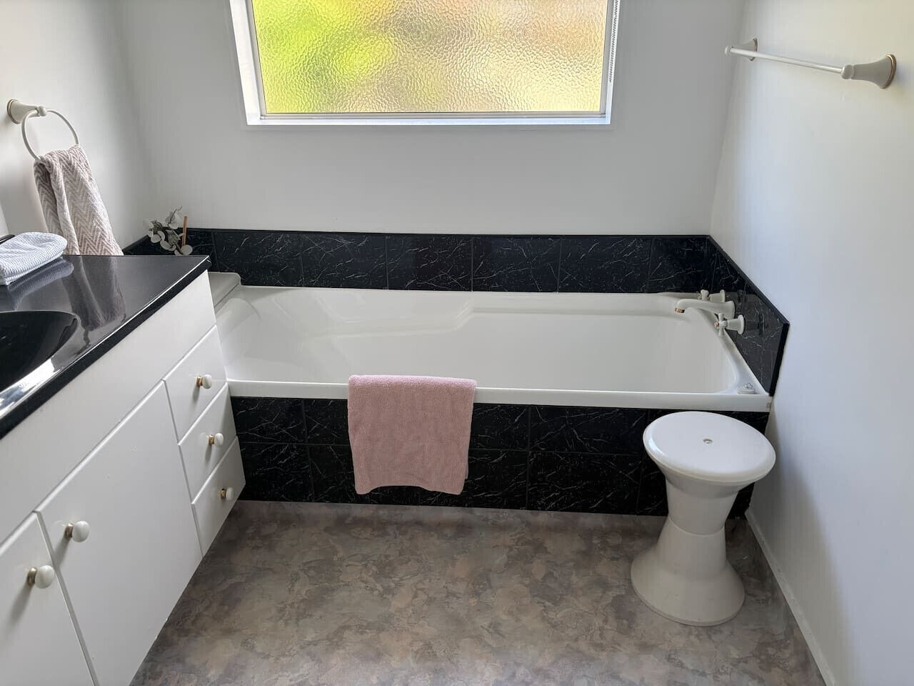 Une salle de bain avec une baignoire, des toilettes et une fenêtre.