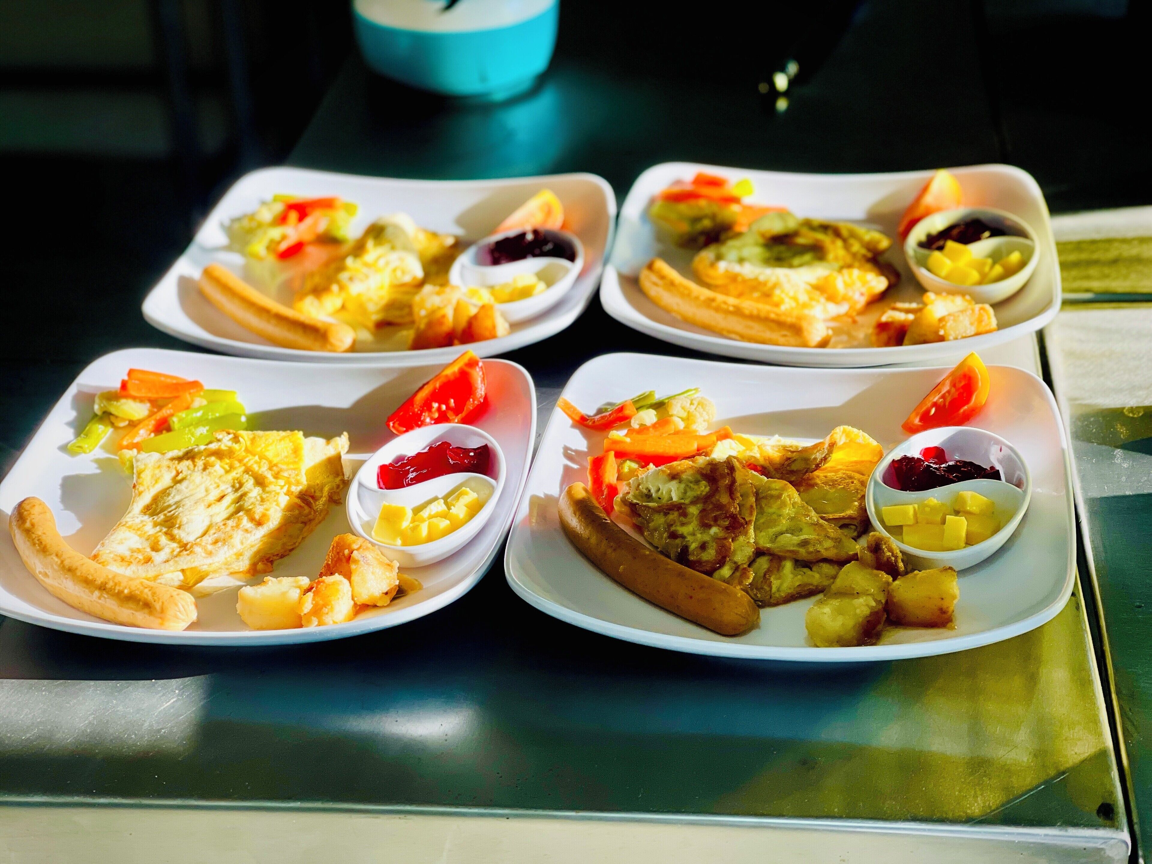 Cuatro platos de comida para el desayuno, con huevos, tostadas y verduras.
