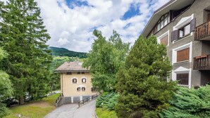 Ein Gebäude mit einem geneigten Dach, umgeben von Bäumen und blauem Himmel.