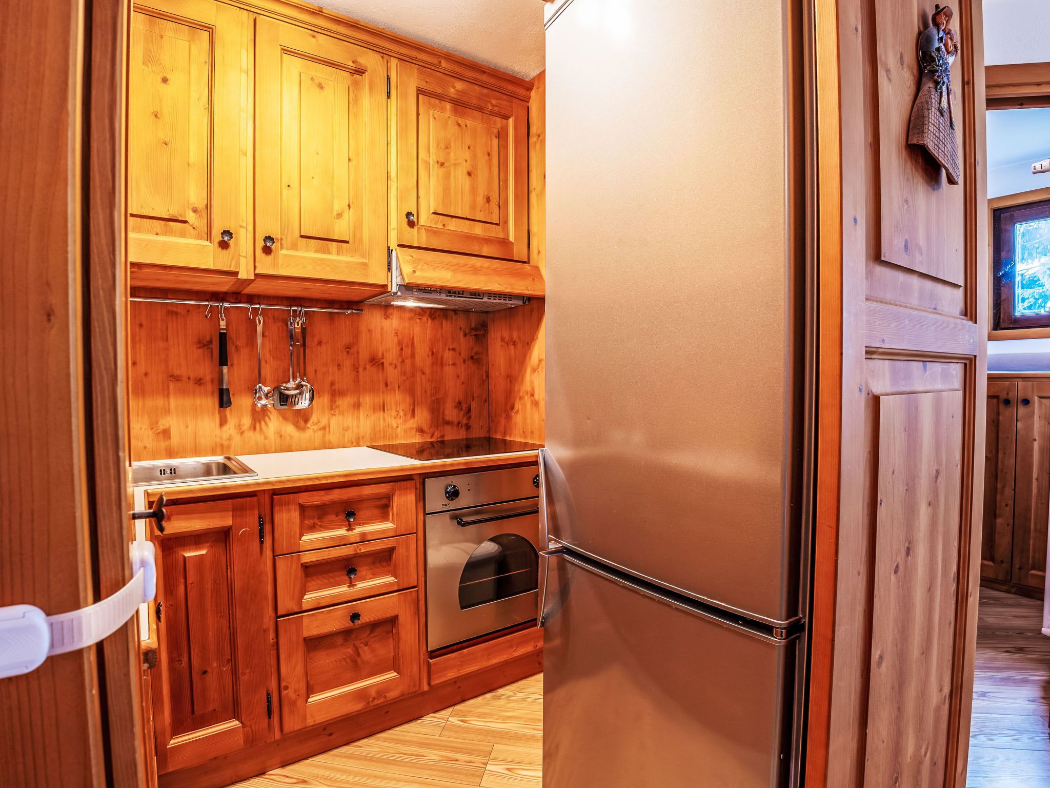 Una cocina con armarios de madera, electrodomésticos de acero inoxidable y un refrigerador.