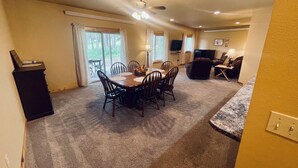 A spacious living area with a dining table, chairs, a sofa, and a television. - Gold Pan Hideaway (Hill City)