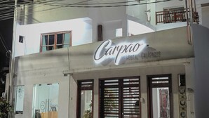 Un edificio de dos pisos con un letrero que dice 'Carpao Hostal Galapagos'.