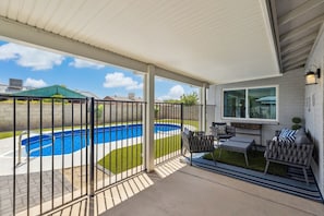 A covered patio with a swimming pool, outdoor seating, and a view of the neighborhood. - Unique Luxury Daily Monthly Rent Near ASU Pet Friendly Pool (Tempe)