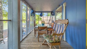 A covered porch with a table and chairs, wooden columns, and a view of the outdoors. - Charming 2-bedroom cabin in beautiful Mountain Rest on Lake Becky (Mountain Rest)