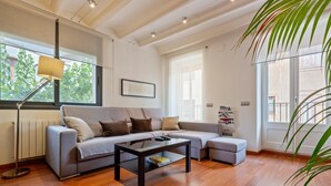 Un salon moderne avec un canapé gris, une table basse et un lampadaire.