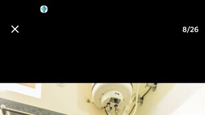 Un baño con inodoro, ducha y barra para toallas.