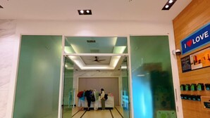 Un hall d’hôtel avec une cloison en verre, un ventilateur de plafond et un panneau sur lequel on peut lire : « J’AIME ».