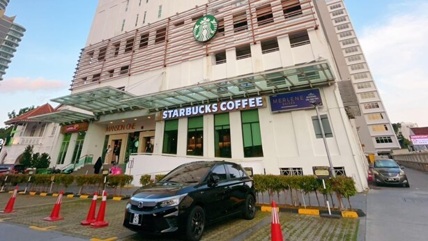 Un immeuble de grande hauteur avec un café Starbucks au rez-de-chaussée.