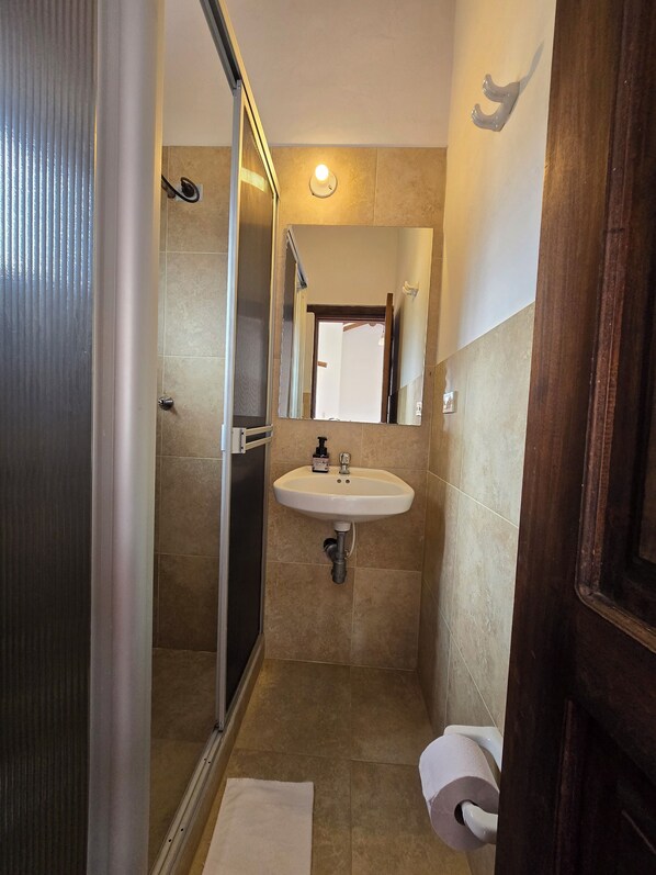 Un bagno compatto con doccia, lavandino e WC.