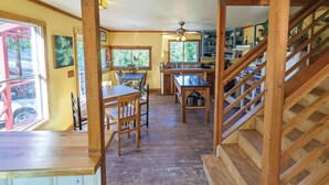 A wooden interior with a dining area, kitchen, and staircase. - Jackass Hostel (North Fork)