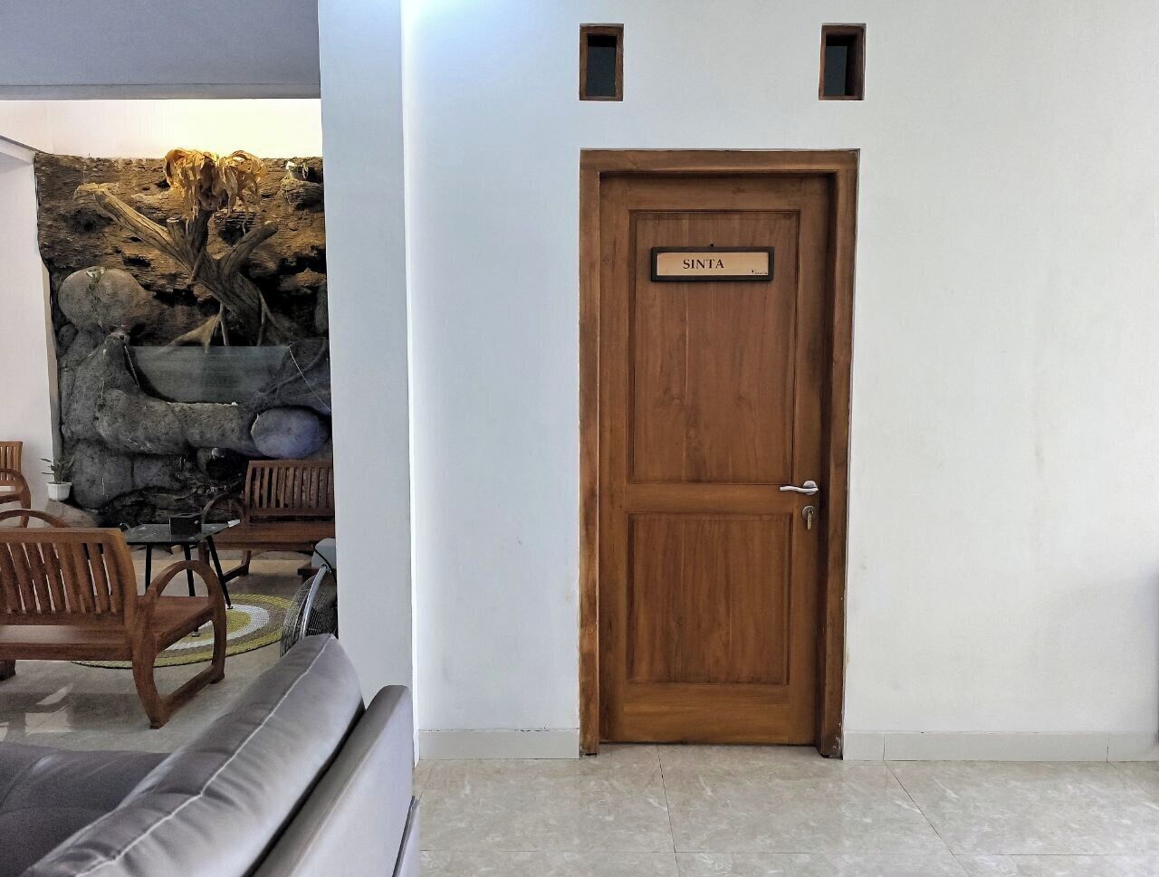 Eine Holztür mit einem Schild mit der Aufschrift "SANTA" und eine Steinwand mit rustikalem Design.