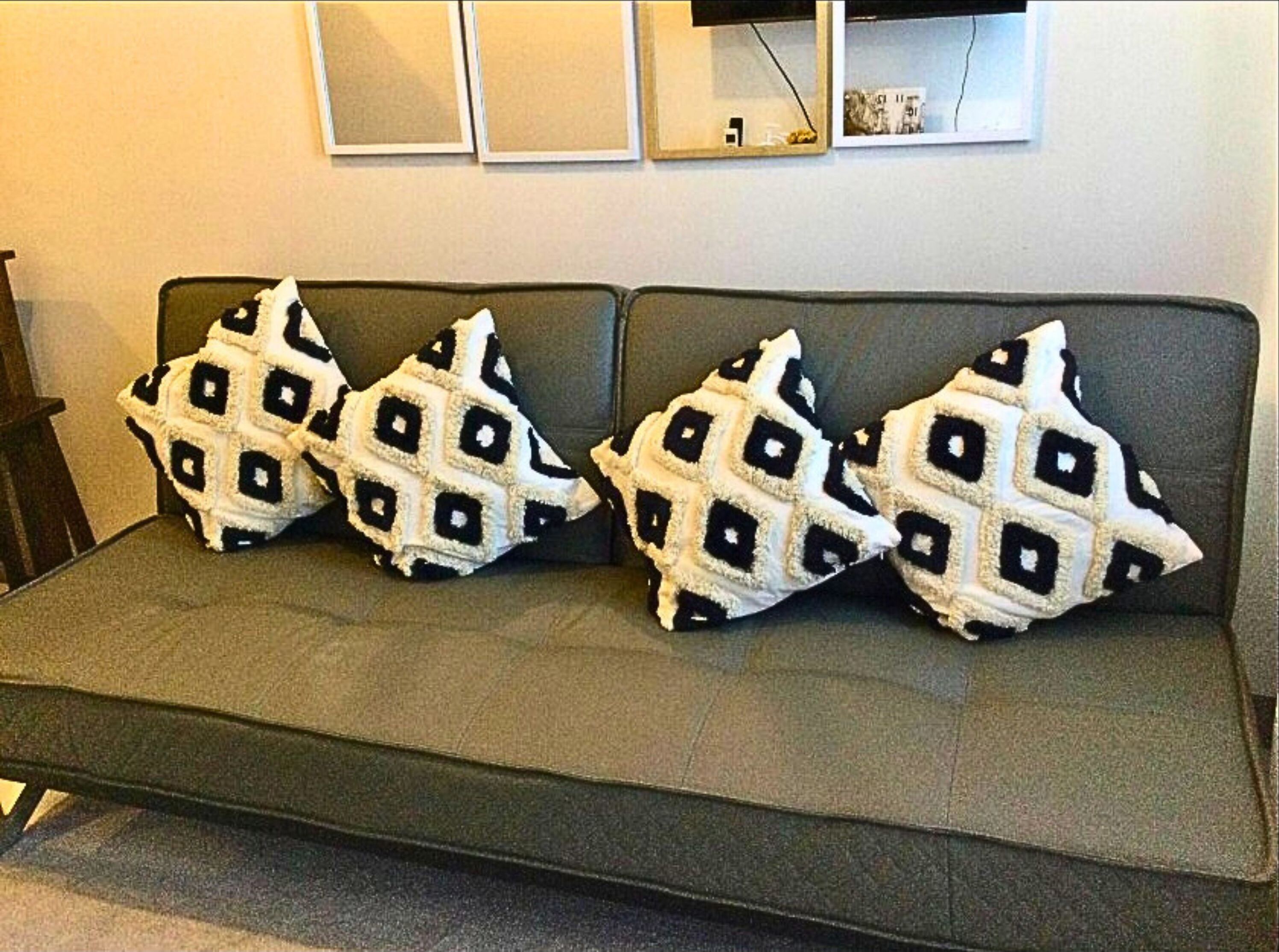 A sofa with three patterned cushions.