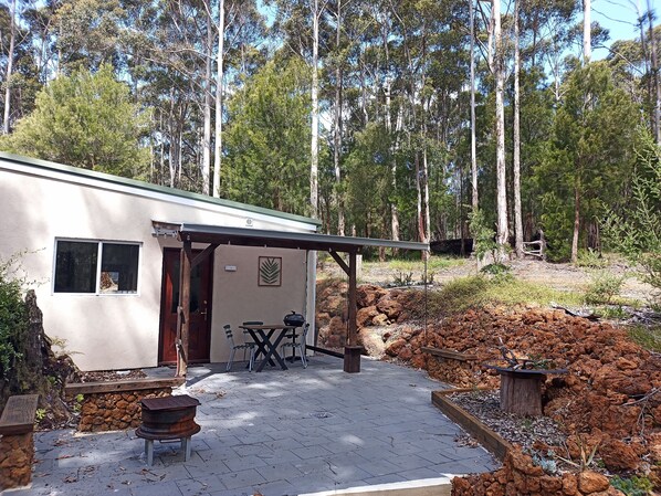 A small building with a patio area, outdoor seating, and a barbecue grill. - Peaceful relaxing Getaway in Karri Forest bordering a Nature Reserve. (Kentdale)