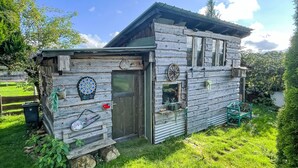 A rustic wooden cabin with a door, windows, and a dartboard. - Vacation home Baur by Interhome (Neureichenau)