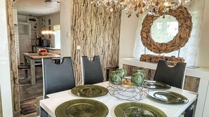 A dining area with a white table, green plates, and black chairs. - Vacation home Baur by Interhome (Neureichenau)